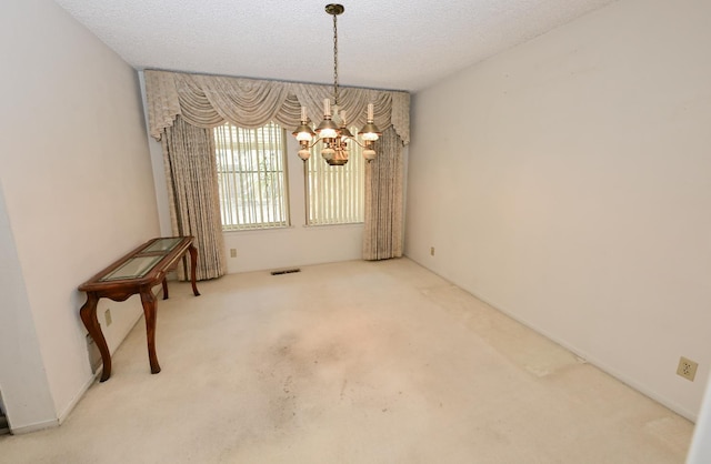1911 W Simpson Ave, Fresno, CA 93705 - unfurnished dining area featuring a chandelier, carpet floors, and a textured ceiling