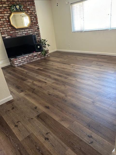 1173 Menlo Ave, Clovis, CA 93612 - unfurnished living room with dark wood finished floors, baseboards, and a fireplace