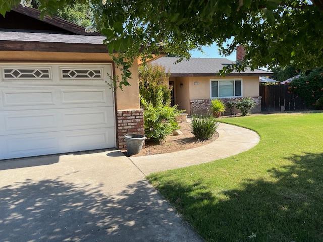 1173 Menlo Ave, Clovis, CA 93612 - single story home with driveway, a chimney, stone siding, an attached garage, and stucco siding