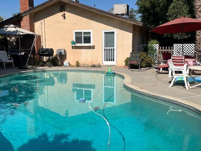 1173 Menlo Ave, Clovis, CA 93612 - swimming pool featuring a patio area, central AC unit, and a grill