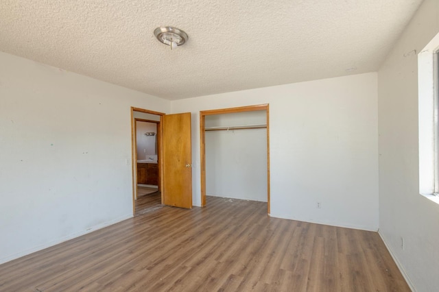208 N 5th St, Fowler, CA 93625 - unfurnished bedroom with wood finished floors, a closet, a textured ceiling, and baseboards