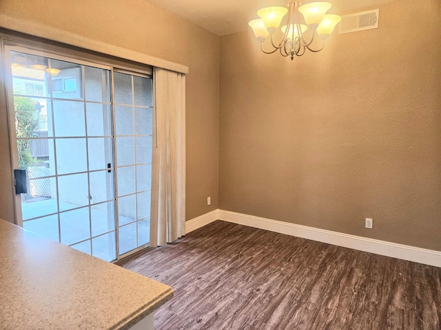 8147 N Cedar Ave Unit 115, Fresno, CA 93720 - unfurnished dining area featuring dark wood finished floors, baseboards, and a chandelier