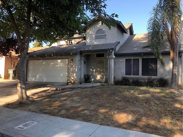 3546 N Berlin Ave, Fresno, CA 93722 - view of front of home featuring stucco siding, concrete driveway, an attached garage, and a tiled roof