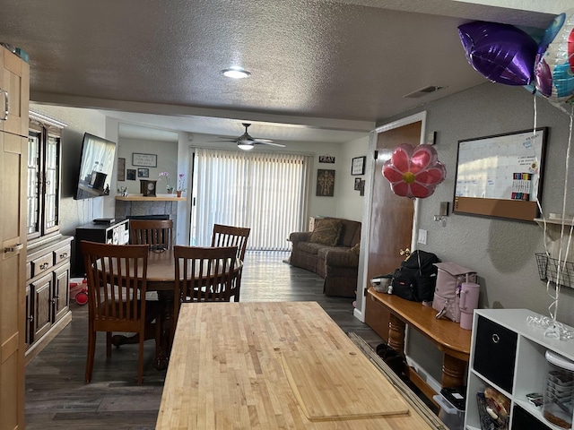 4885 N Backer Ave Unit 148, Fresno, CA 93726 - dining space featuring dark wood finished floors, a textured wall, a textured ceiling, and ceiling fan