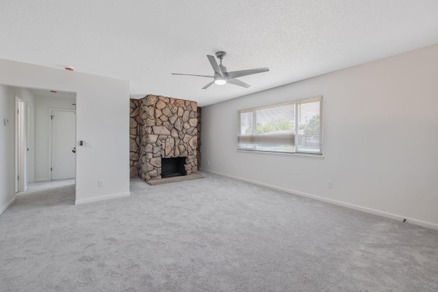 955 W San Gabriel Ave, Clovis, CA 93612 - unfurnished living room featuring a ceiling fan, baseboards, carpet, a stone fireplace, and a textured ceiling