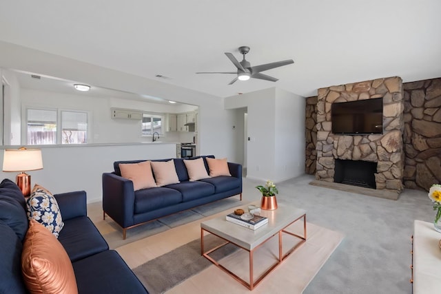 955 W San Gabriel Ave, Clovis, CA 93612 - living room with a ceiling fan, a stone fireplace, and light colored carpet