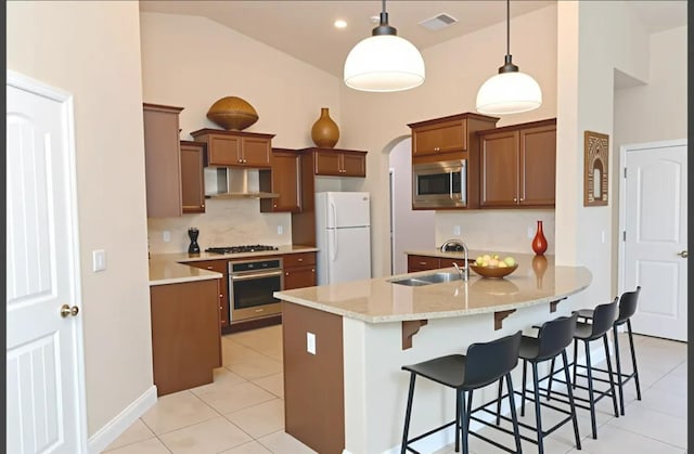 7285 W San Jose Ave, Fresno, CA 93723 - kitchen with appliances with stainless steel finishes, wall chimney exhaust hood, a sink, light tile patterned floors, and high vaulted ceiling