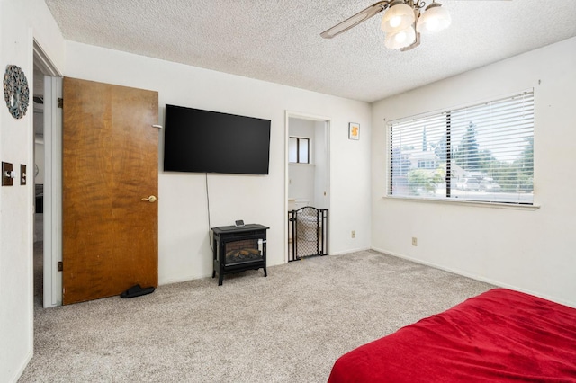 772 W Menlo Ave, Clovis, CA 93612 - carpeted bedroom with a wood stove, a textured ceiling, and ceiling fan