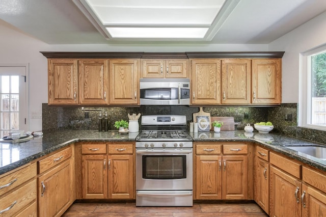770 N Cherry Ln, Clovis, CA 93611 - kitchen with stainless steel appliances, decorative backsplash, dark stone countertops, and dark wood-style flooring