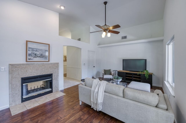 770 N Cherry Ln, Clovis, CA 93611 - living area with arched walkways, ceiling fan, a tile fireplace, wood finished floors, and baseboards