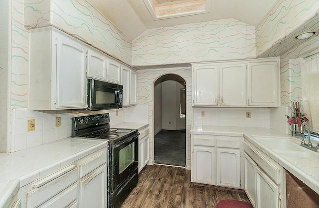 7543 N Spalding Ave, Fresno, CA 93720 - kitchen with black appliances, tile counters, vaulted ceiling, arched walkways, and tasteful backsplash