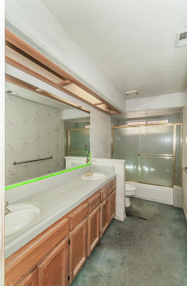 7543 N Spalding Ave, Fresno, CA 93720 - full bathroom featuring double vanity, a textured ceiling, toilet, and enclosed tub / shower combo