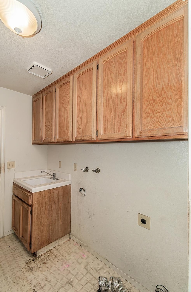 7543 N Spalding Ave, Fresno, CA 93720 - laundry area featuring hookup for an electric dryer, light flooring, cabinet space, a textured ceiling, and washer hookup