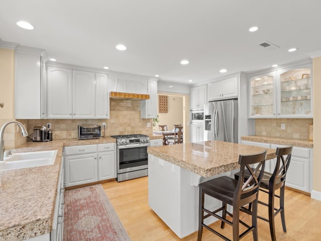 811 E Country View Cir, Fresno, CA 93730 - kitchen with stainless steel appliances, tasteful backsplash, custom exhaust hood, white cabinets, and light countertops