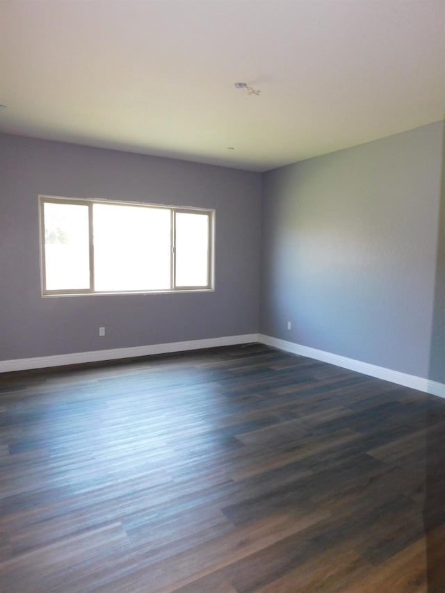 5875 E Pitt Ave, Fresno, CA 93727 - spare room with dark wood-style floors and baseboards