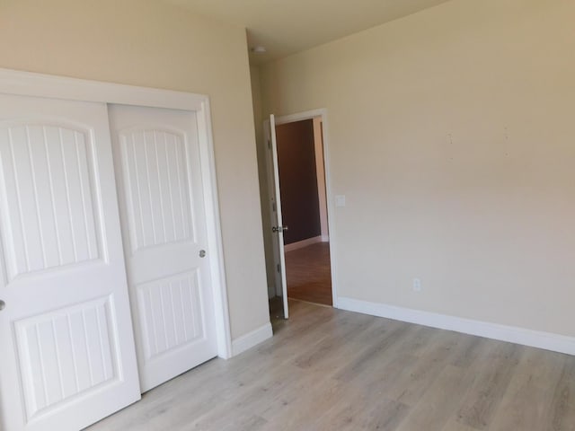5875 E Pitt Ave, Fresno, CA 93727 - unfurnished bedroom featuring light wood-style floors, a closet, and baseboards