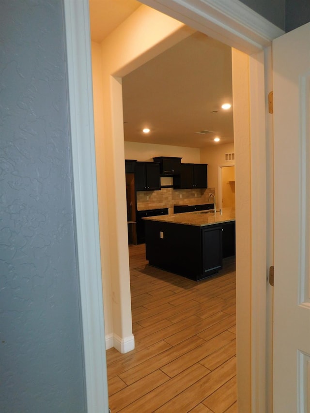 5875 E Pitt Ave, Fresno, CA 93727 - kitchen featuring dark cabinets, a sink, backsplash, light wood-style flooring, and recessed lighting