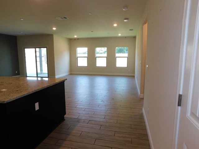 5875 E Pitt Ave, Fresno, CA 93727 - kitchen featuring wood finished floors, baseboards, open floor plan, recessed lighting, and light stone counters