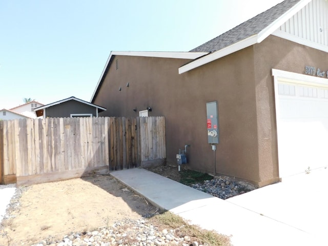 5875 E Pitt Ave, Fresno, CA 93727 - view of property exterior with stucco siding, a shingled roof, and board and batten siding