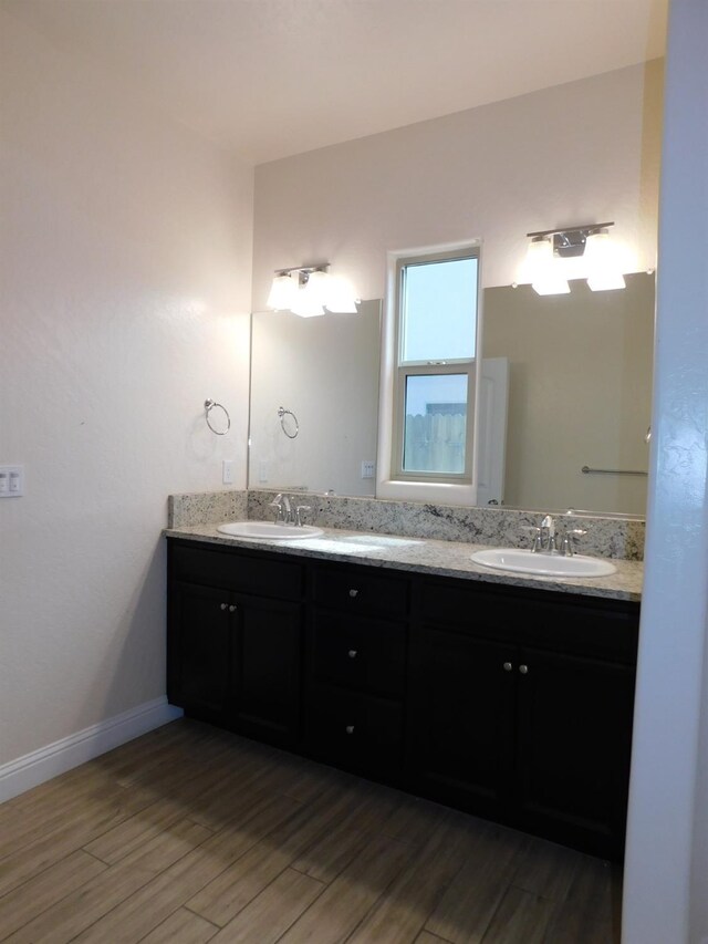 5875 E Pitt Ave, Fresno, CA 93727 - bathroom featuring double vanity and wood finished floors