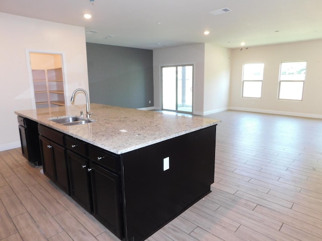 5875 E Pitt Ave, Fresno, CA 93727 - kitchen with a sink, dark cabinetry, open floor plan, light wood-style floors, and recessed lighting
