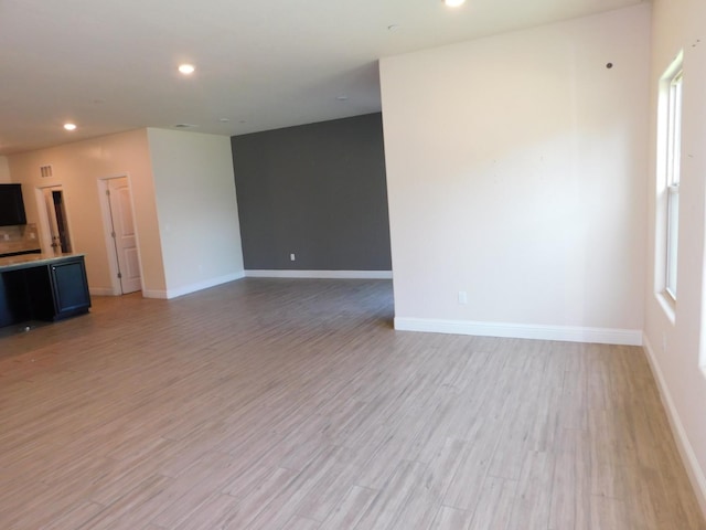 5875 E Pitt Ave, Fresno, CA 93727 - unfurnished living room with light wood-type flooring, baseboards, and recessed lighting