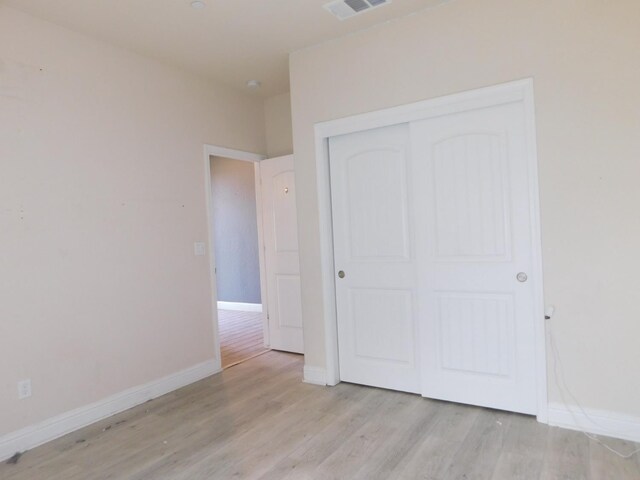 5875 E Pitt Ave, Fresno, CA 93727 - unfurnished bedroom with light wood finished floors, a closet, and baseboards