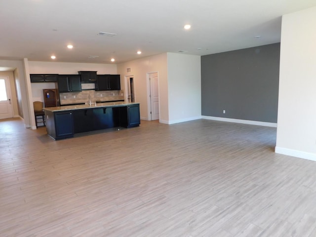 5875 E Pitt Ave, Fresno, CA 93727 - kitchen featuring open floor plan, backsplash, an island with sink, baseboards, and recessed lighting