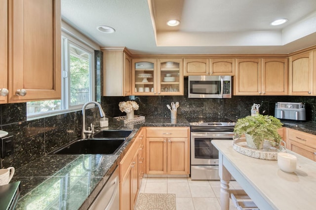 1758 Ash Ave, Clovis, CA 93611 - kitchen featuring appliances with stainless steel finishes, light brown cabinets, glass insert cabinets, backsplash, and recessed lighting