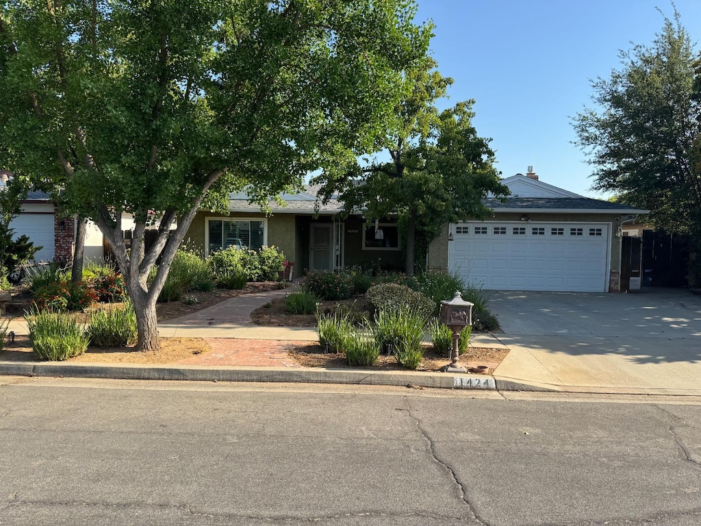 1424 W Chennault Ave, Fresno, CA 93711 - view of front of house with a garage, driveway, and stucco siding