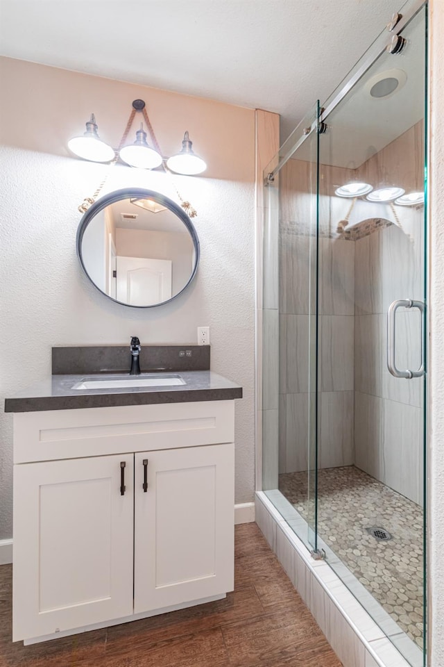 697 E Omaha Ave, Fresno, CA 93720 - full bath with vanity, wood finished floors, a stall shower, and baseboards
