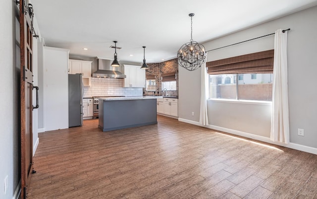 697 E Omaha Ave, Fresno, CA 93720 - kitchen featuring wall chimney exhaust hood, freestanding refrigerator, a chandelier, recessed lighting, and plenty of natural light