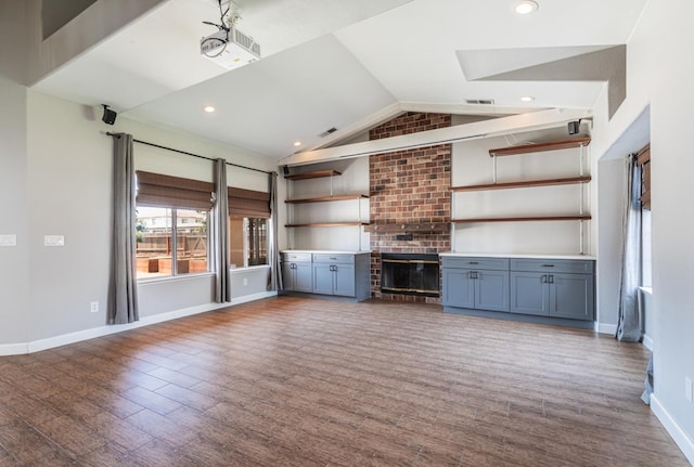 697 E Omaha Ave, Fresno, CA 93720 - unfurnished living room featuring vaulted ceiling, wood finished floors, a brick fireplace, baseboards, and recessed lighting