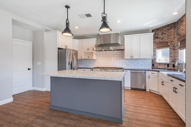 697 E Omaha Ave, Fresno, CA 93720 - kitchen featuring appliances with stainless steel finishes, wall chimney exhaust hood, tasteful backsplash, a sink, and white cabinetry