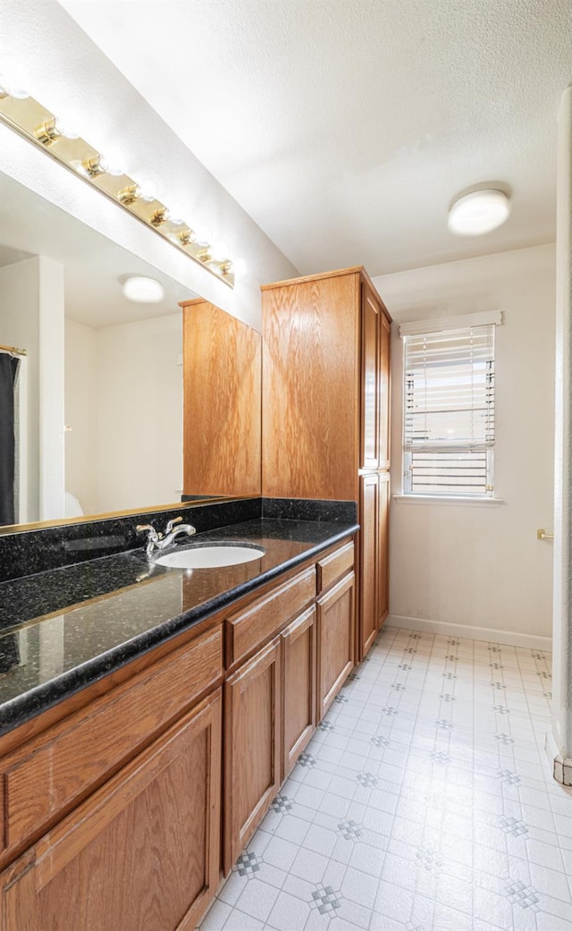 697 E Omaha Ave, Fresno, CA 93720 - bathroom with vanity, baseboards, and a textured ceiling