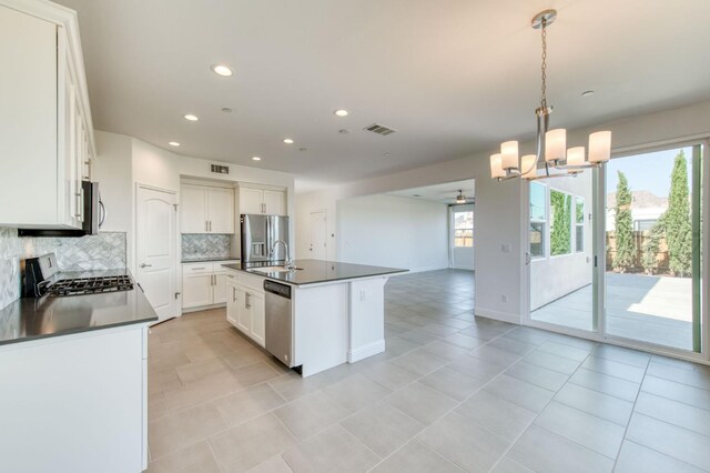 3923 Morris Ave, Clovis, CA 93619 - kitchen featuring appliances with stainless steel finishes, dark countertops, a sink, decorative backsplash, and recessed lighting