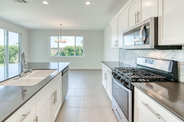 3923 Morris Ave, Clovis, CA 93619 - kitchen with stainless steel appliances, a sink, a chandelier, decorative backsplash, and recessed lighting