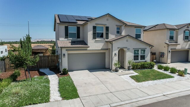 3923 Morris Ave, Clovis, CA 93619 - view of front of home with stucco siding, an attached garage, solar panels, and driveway