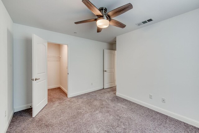 3923 Morris Ave, Clovis, CA 93619 - unfurnished bedroom featuring light colored carpet, baseboards, a walk in closet, a closet, and a ceiling fan
