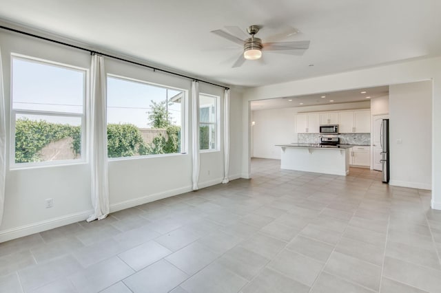 3923 Morris Ave, Clovis, CA 93619 - unfurnished living room featuring ceiling fan, baseboards, and light tile patterned flooring