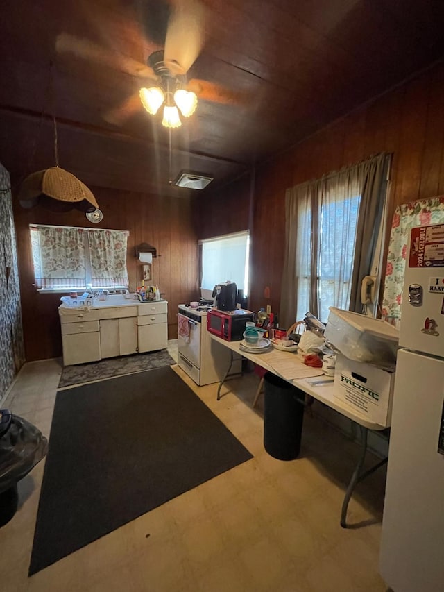 2419 Knowles, Selma, CA 93662 - kitchen with white appliances, wooden walls, light flooring, and a ceiling fan