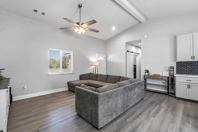 22375 Fairmead Cir, Chowchilla, CA 93610 - living area with a barn door, beamed ceiling, a ceiling fan, wood finished floors, and high vaulted ceiling