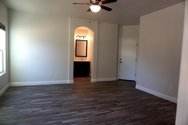 29030 Yosemite Springs Pkwy, Coarsegold, CA 93614 - spare room featuring arched walkways, a ceiling fan, dark wood-type flooring, and baseboards