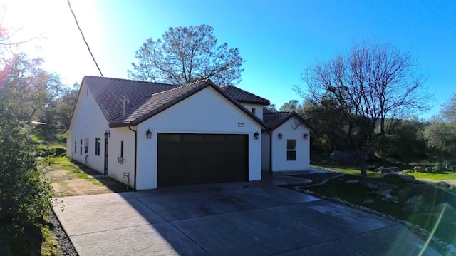 29030 Yosemite Springs Pkwy, Coarsegold, CA 93614 - view of side of home with a garage, stucco siding, concrete driveway, and a tile roof