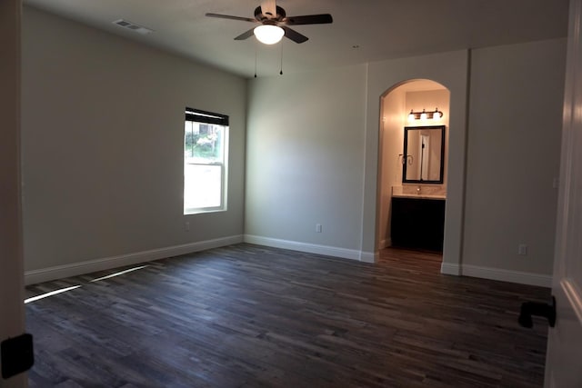 29030 Yosemite Springs Pkwy, Coarsegold, CA 93614 - empty room featuring arched walkways, a ceiling fan, dark wood finished floors, and baseboards