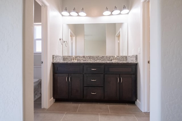 858 N Palm St, Woodlake, CA 93286 - full bathroom featuring double vanity, toilet, tile patterned floors, and baseboards