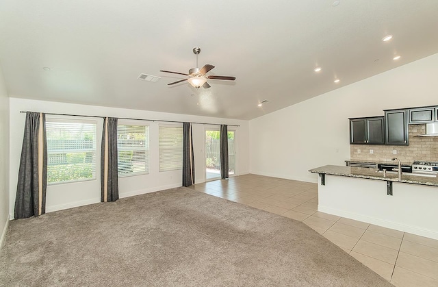 461 S Cascade Way, Madera, CA 93636 - unfurnished living room featuring lofted ceiling, light tile patterned floors, a ceiling fan, light carpet, and recessed lighting