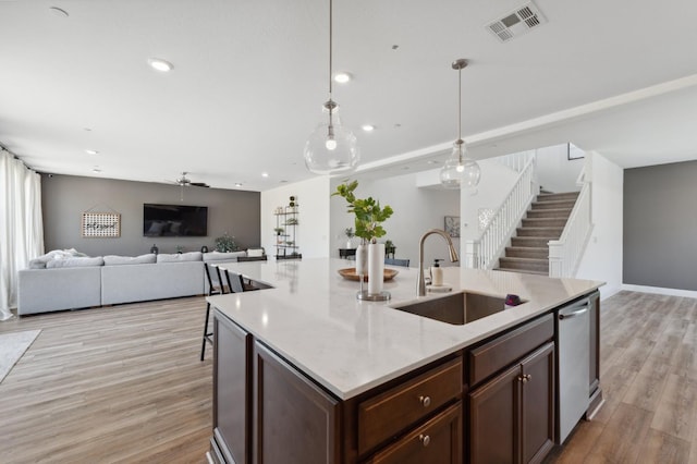 6406 E Giavanna Ave, Fresno, CA 93727 - kitchen featuring light wood-type flooring, pendant lighting, stainless steel dishwasher, recessed lighting, and a kitchen island with sink