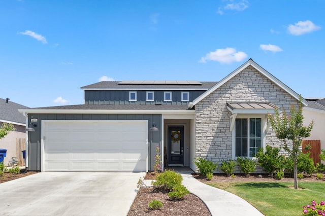 6406 E Giavanna Ave, Fresno, CA 93727 - view of front of property with board and batten siding, solar panels, driveway, stone siding, and an attached garage