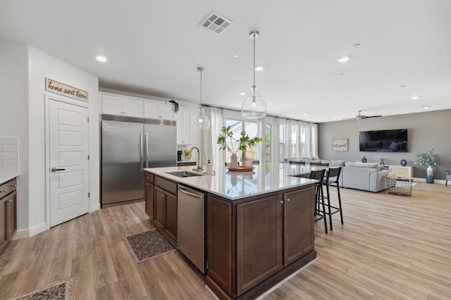 6406 E Giavanna Ave, Fresno, CA 93727 - kitchen with appliances with stainless steel finishes, dark brown cabinets, recessed lighting, light countertops, and light wood-type flooring